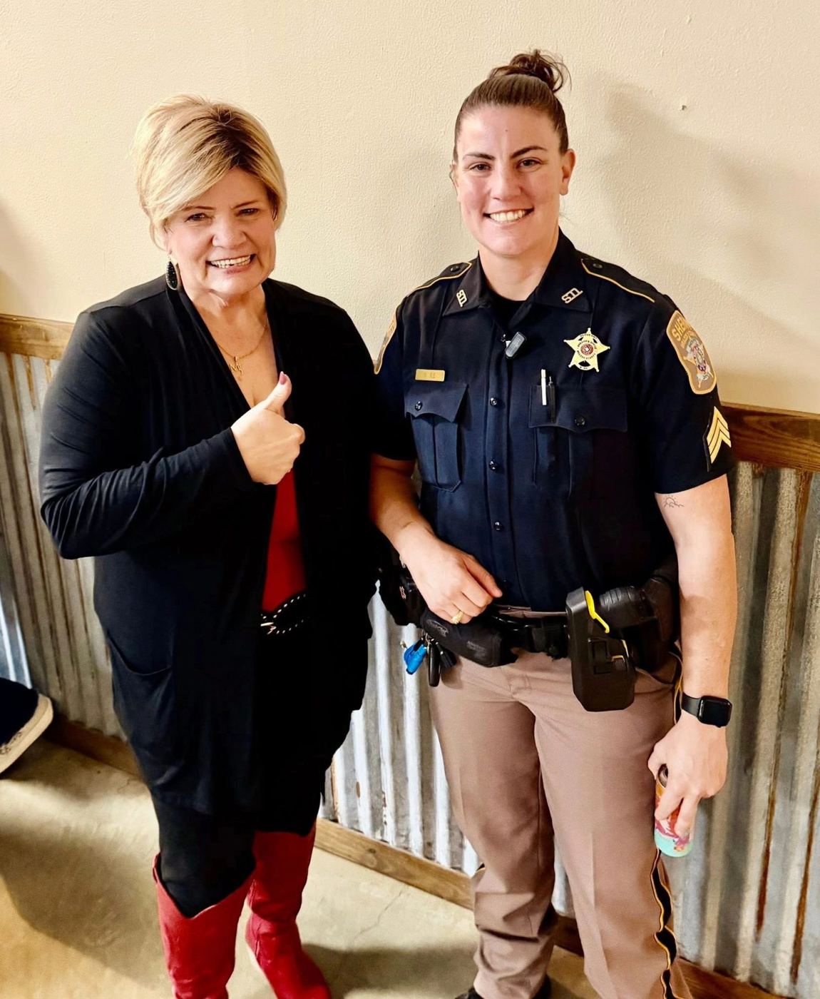 Two guests, one a uniformed deputy, smiling